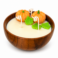 Pumpkin Harvest Candle - hand-poured soy wax candle in a wood bowl with two mini pumpkins and green leaf decorations