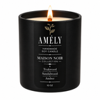 Maison Noir Collection candle in Amber scent, lit, on a white background