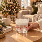 Snow Globe candle on a wood table beside a Christmas tree