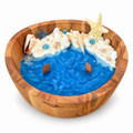 Ocean Bowl Candle in a round wood bowl with blue wax, white foam and seashells